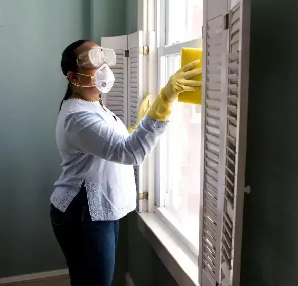 Professional female cleaner providing window cleaning services in Abu Dhabi